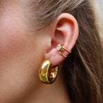 Delia Ear Cuff in Gold mit Zirkonia-Stein und Ava Hoops Ohrclips am Ohr getragen