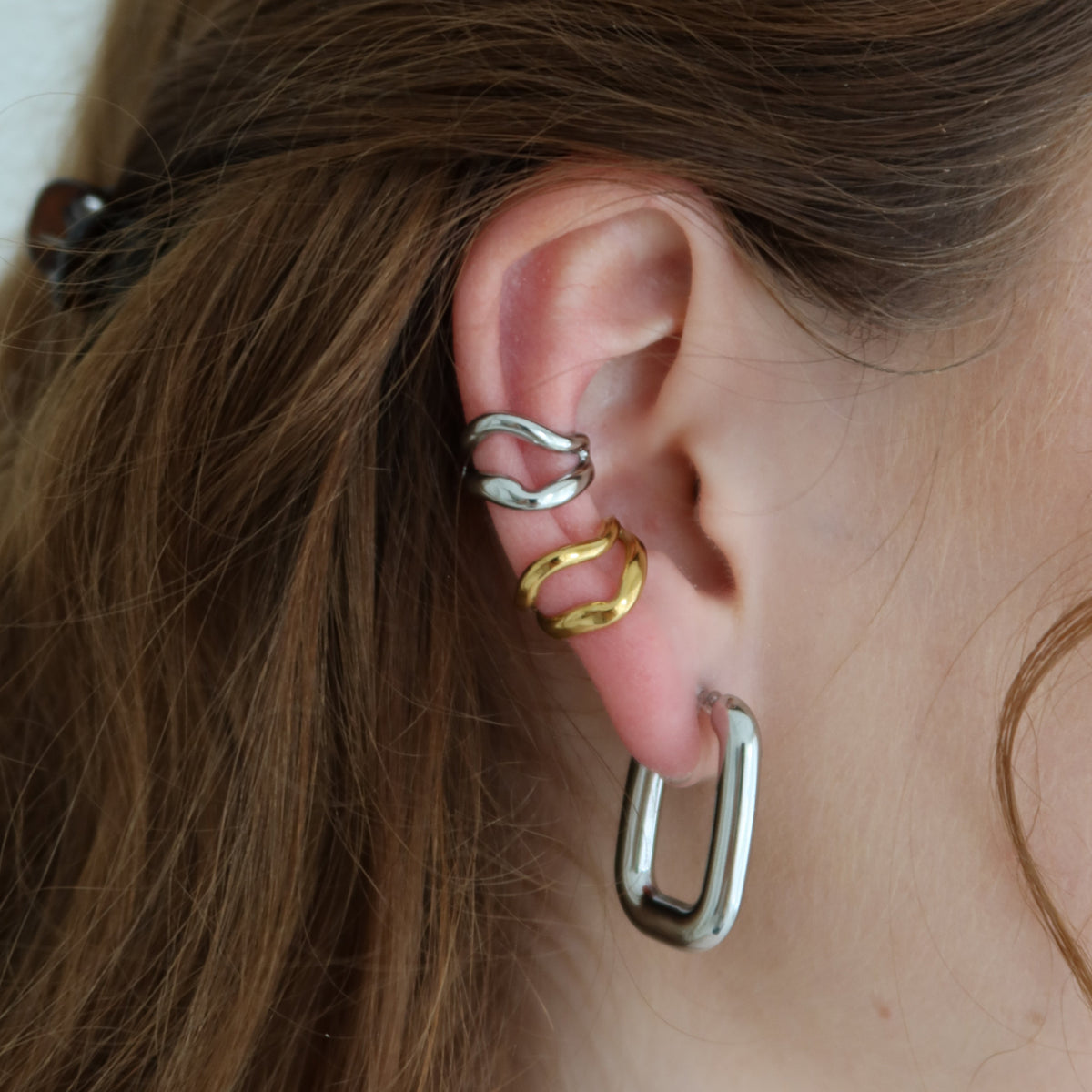 Ines Ohrclips in Silber am Ohr getragen mit Vaina Ear Cuffs in silber und gold