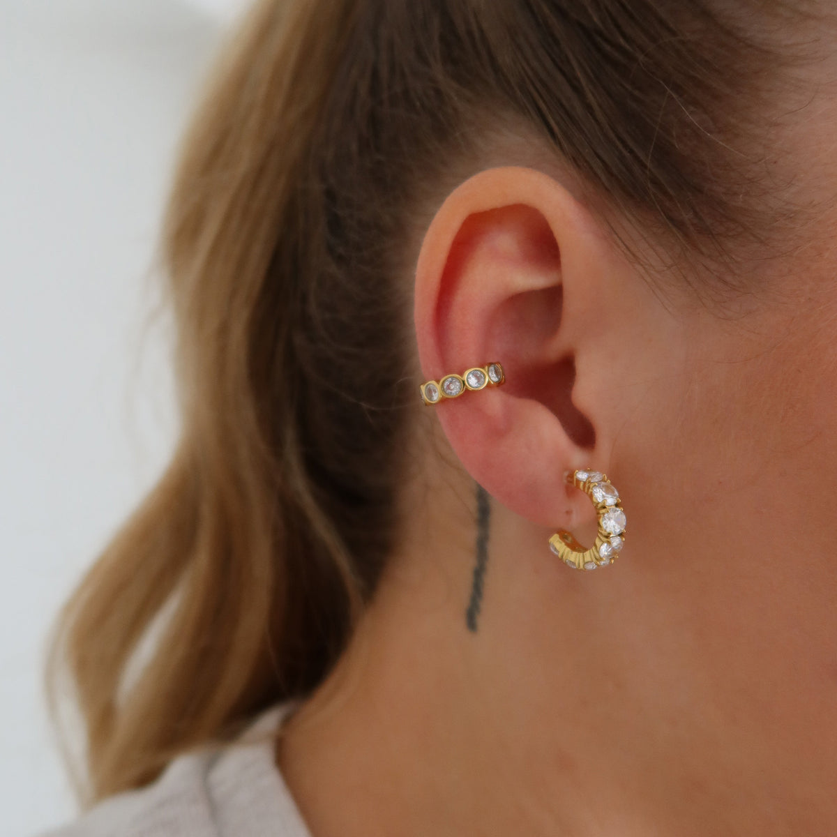 Julia Hoops Ohrclips in Gold und Juliette Ear Cuff in Gold am Ohr getragen